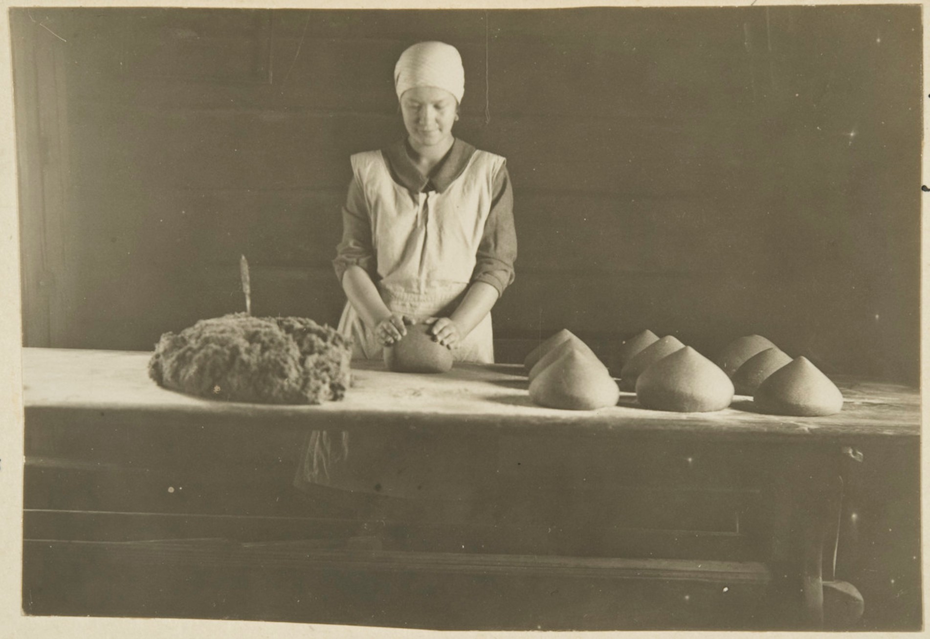 Maiju Lapveteläinen leipoo Pitkä-Ahossa, taikinaa pyöritellään leiviksi Rytkönen, Ahti, kuvaaja 1927, Museovirasto Kansatieteen kuvakokoelma