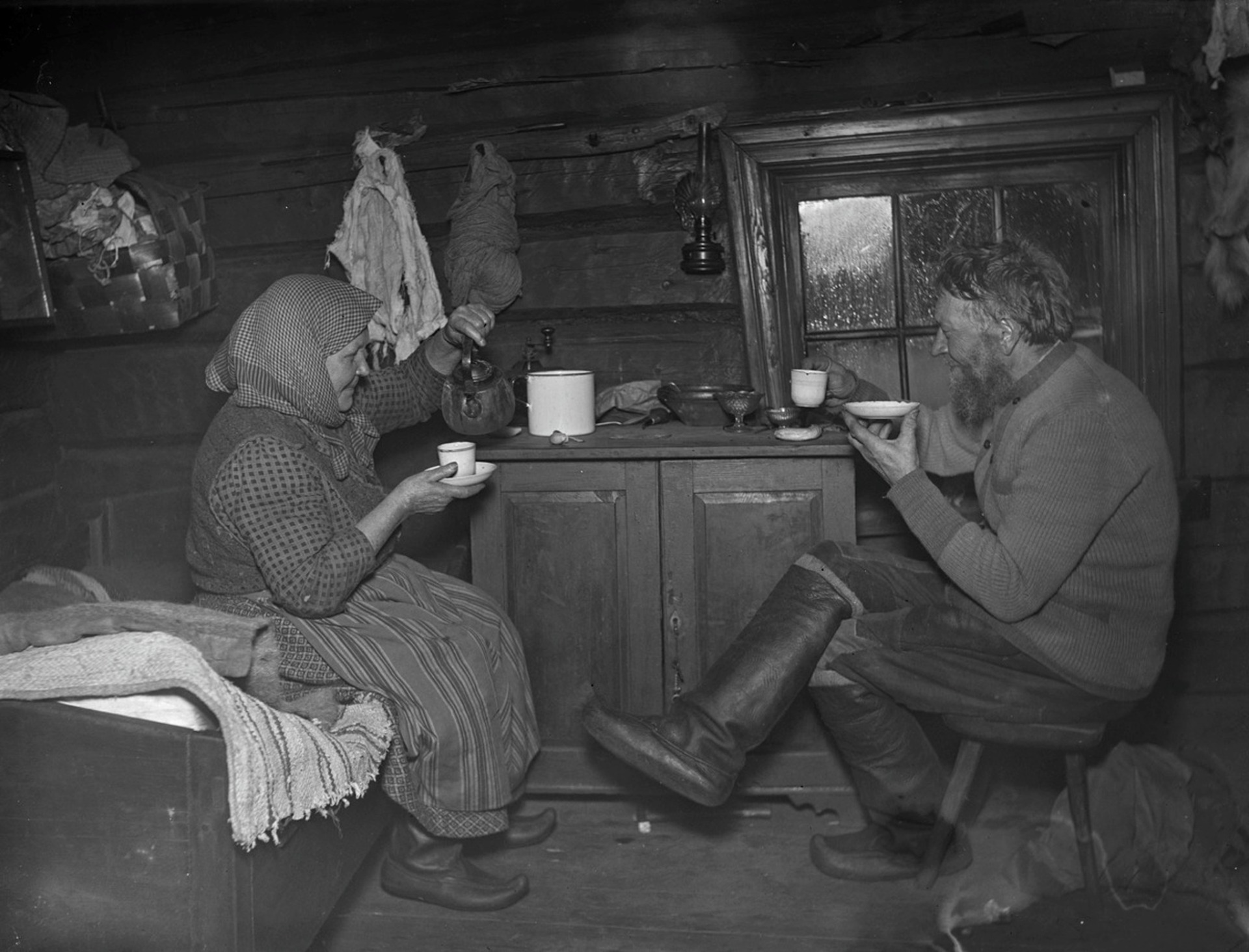 pariskunta nauttimassa kahvia Vatalan savupirtissä Rytkönen, Ahti, kuvaaja 1927, Museovirasto Kansatieteen kuvakokoelma